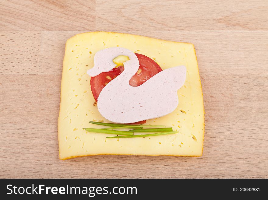 Studio-shot of a wooden board with a slice of healthy school bread for kids with mortadella and chesse,. garnished with chives,and tomato. Studio-shot of a wooden board with a slice of healthy school bread for kids with mortadella and chesse,. garnished with chives,and tomato.