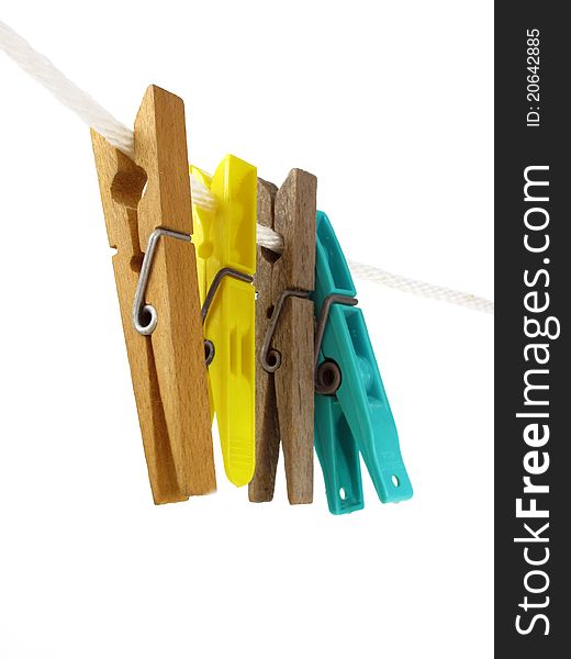 Four spring-clip clothespins on a white rope isolated. Four spring-clip clothespins on a white rope isolated