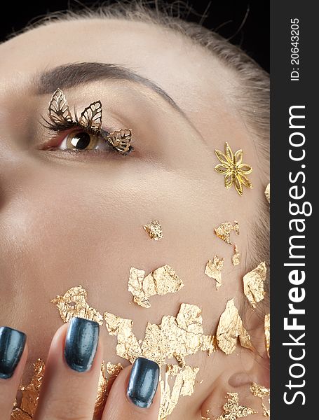 Close-up portrait of beautiful brunette with golden glamor make-up