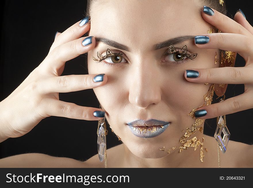 Close-up portrait of beautiful brunette with golden glamor make-up