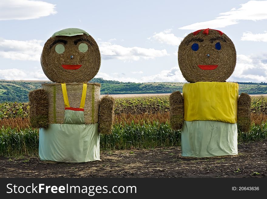 Huge straw couple staying on the field