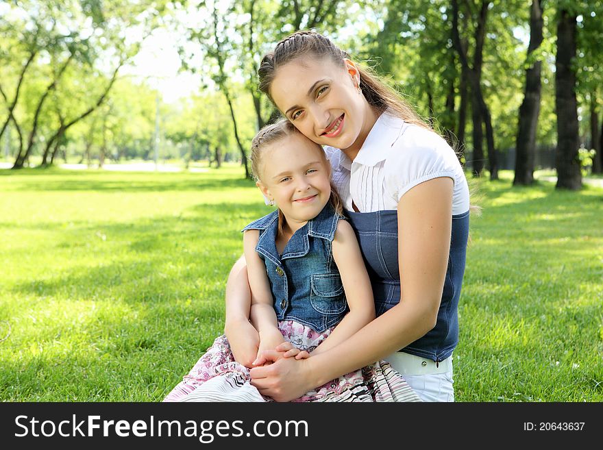 Mother with her daughter outside in the summer park