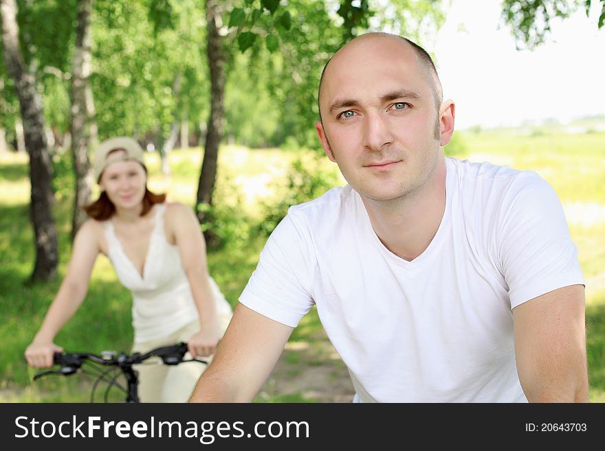Young man riding a bike in the summer park