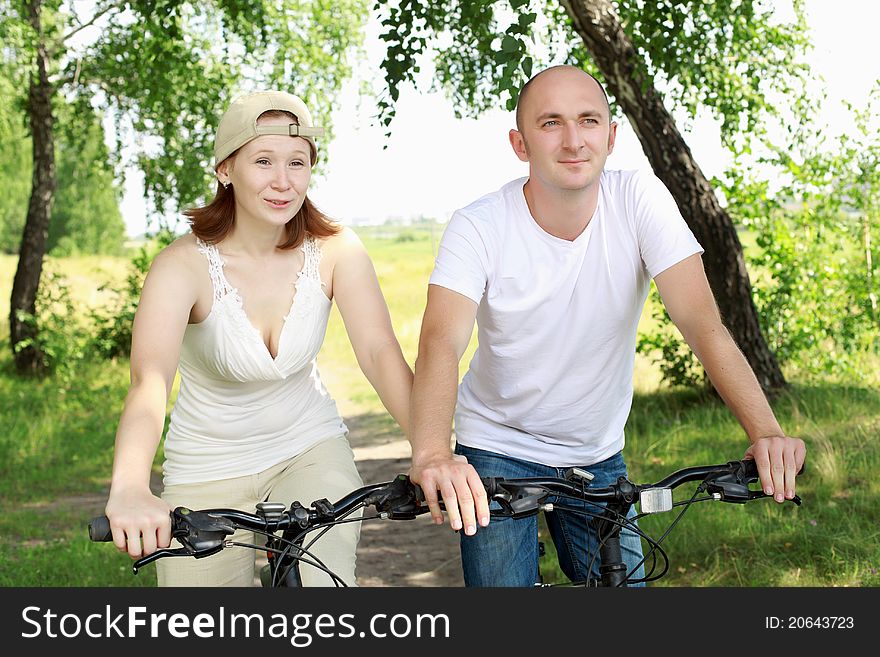 Young couple on the bikes in the park