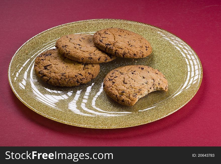 Chocolate cookies on a plate over color background