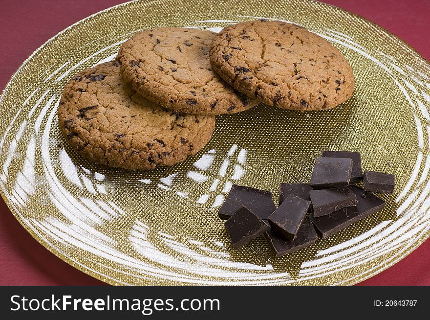 Chocolate and cookies on a plate over color background. Chocolate and cookies on a plate over color background