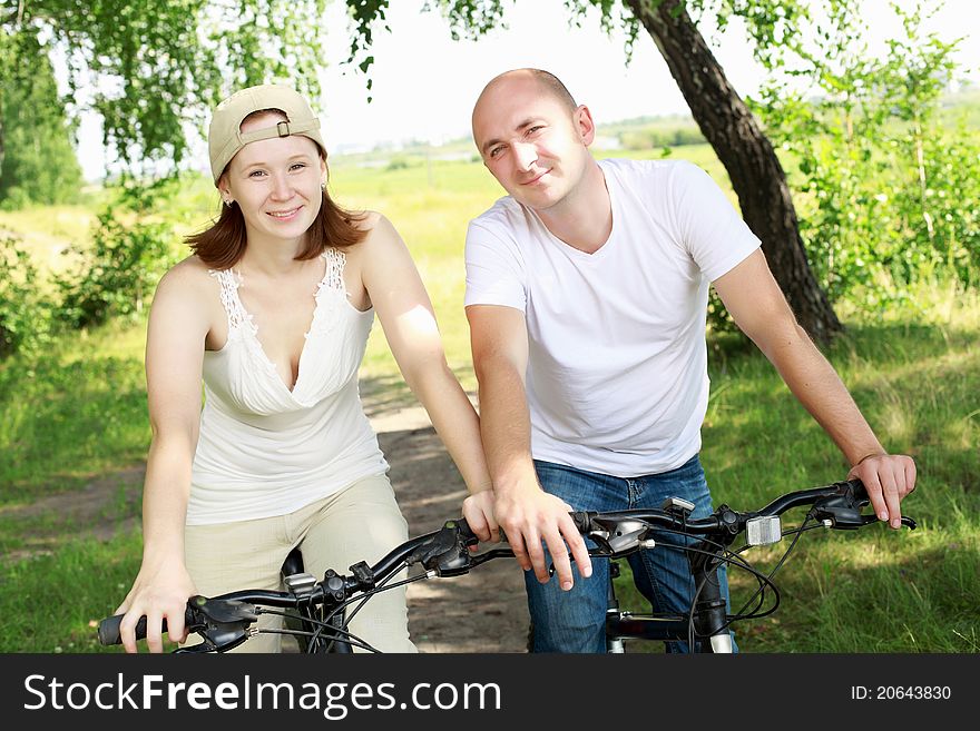 Young couple on the bikes in the park
