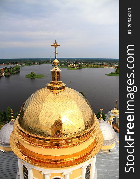 The golden cupola of church in the sky and lake