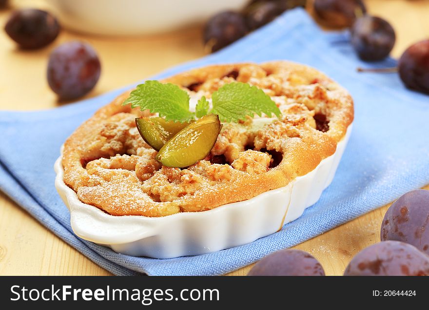 Freshly baked plum cake in a casserole dish