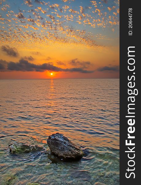 The stones protruding from the water at sunset. The stones protruding from the water at sunset