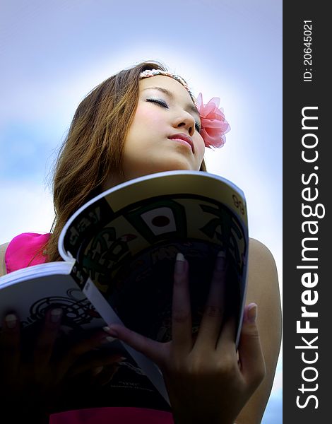 Beautiful Asian woman relaxing over the blue sky. Beautiful Asian woman relaxing over the blue sky.