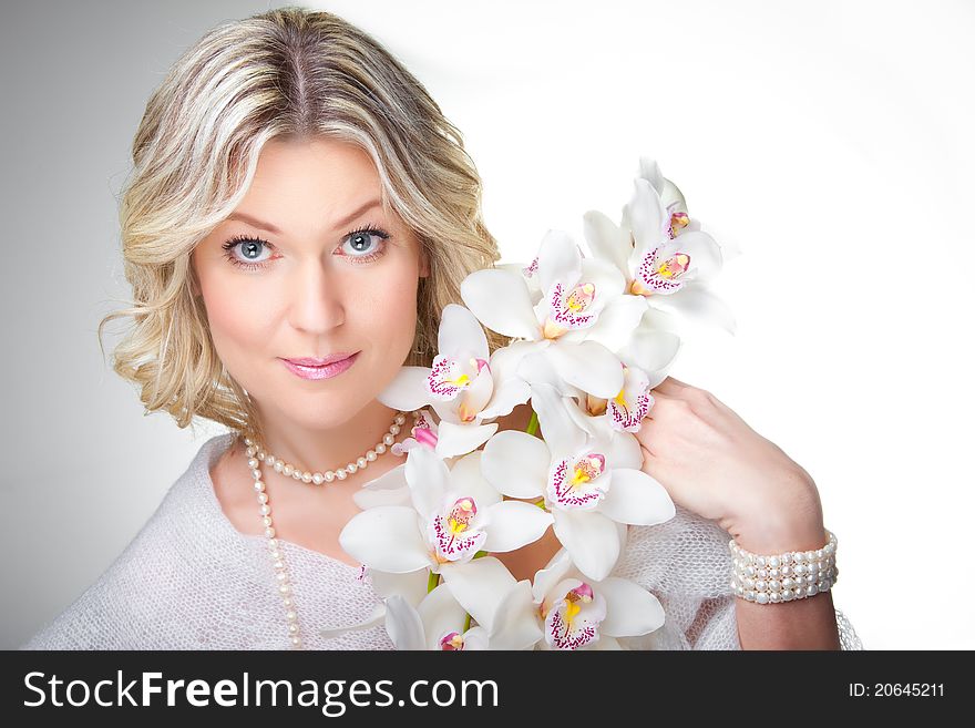 Close-up portrait of beautiful young blonde woman with  flowers  of orchid. Close-up portrait of beautiful young blonde woman with  flowers  of orchid