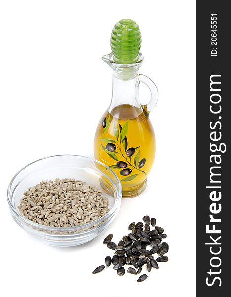 Oil in bottle and sunflower seeds on white background. Oil in bottle and sunflower seeds on white background