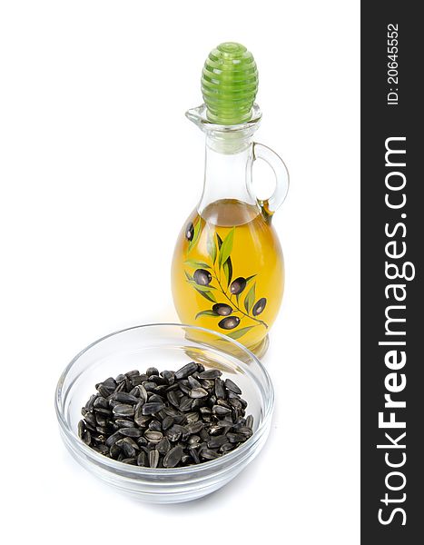 Oil in bottle and sunflower seeds on white background. Oil in bottle and sunflower seeds on white background