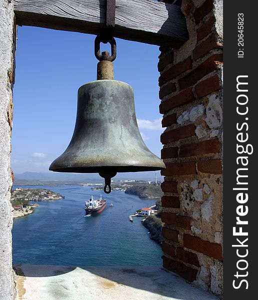Signal bell and an incoming cargo ship at a port entrance. Signal bell and an incoming cargo ship at a port entrance