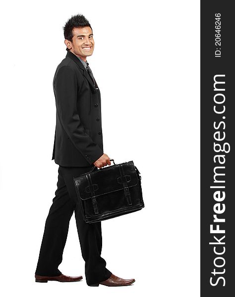 Young businessman is walking and smiling to the camera. isolated over white background