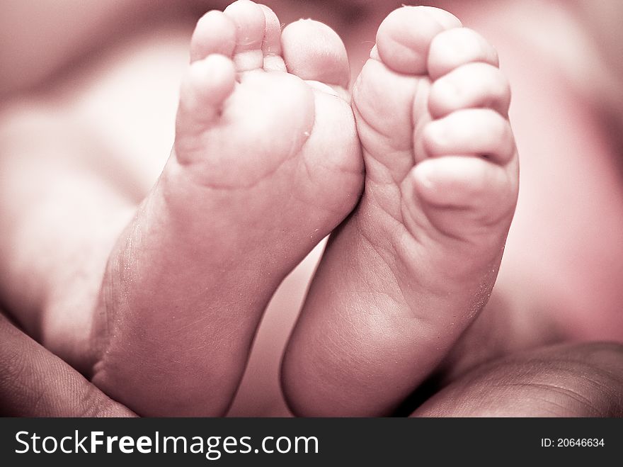 Baby's foot in mother hands closeup