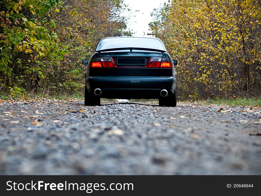 A car on curvy autumn forest road