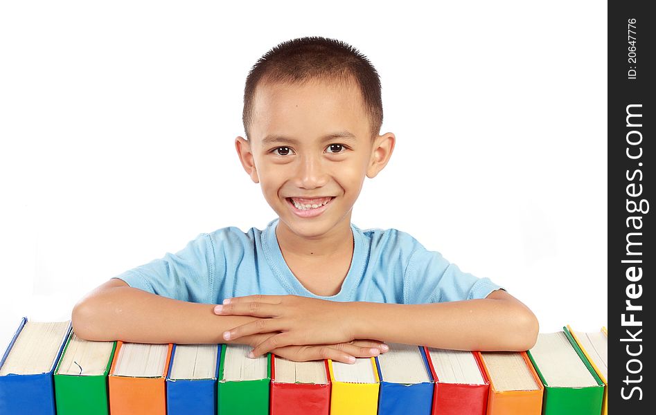 Portrait of young boy smiling on top of his colorful books isolated over white background. Portrait of young boy smiling on top of his colorful books isolated over white background