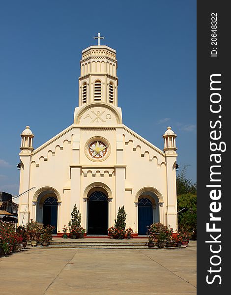 Pastel yellow church against blue sky in Lao PDR.