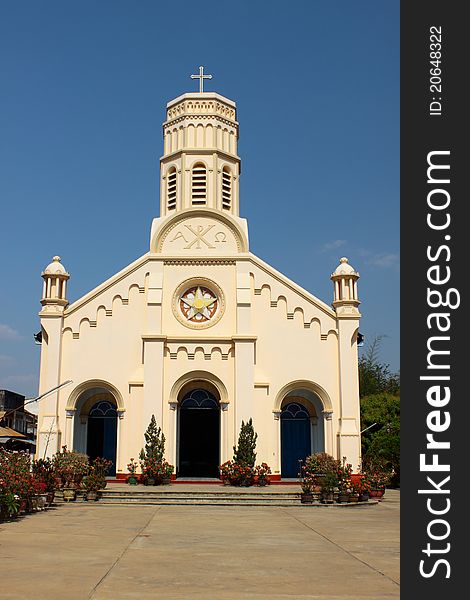 Pastel yellow church against blue sky in Lao PDR.