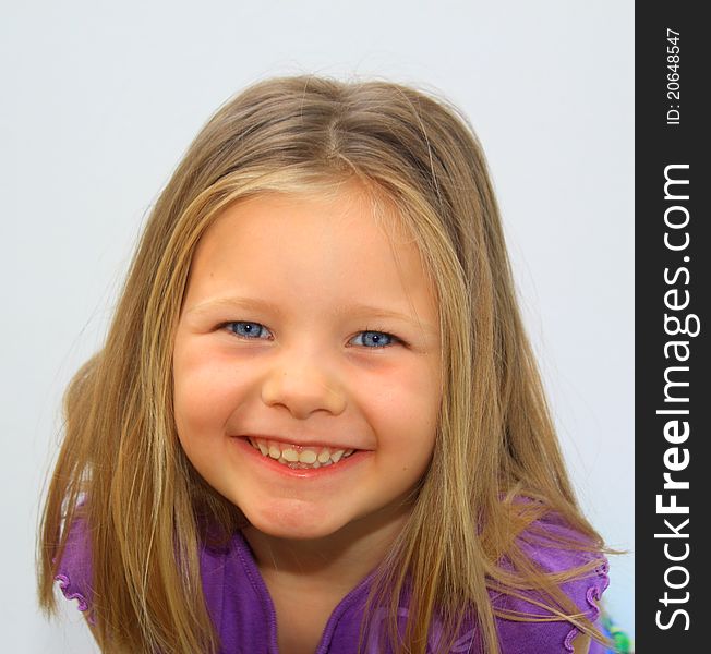 A happy, pretty young girl gives a smile into the camera. A happy, pretty young girl gives a smile into the camera.