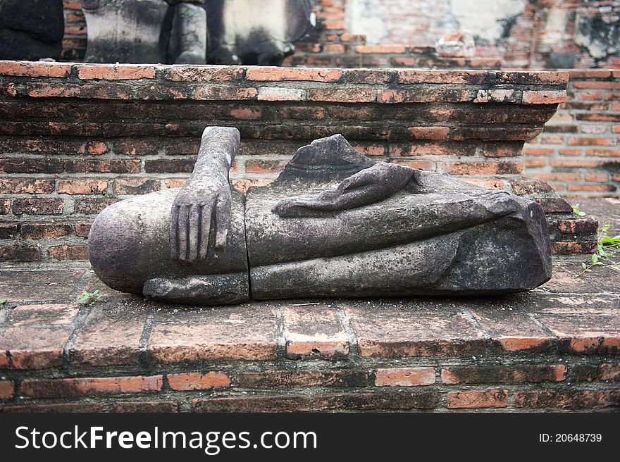 A ruined stone Buddha statue in Ayutthaya, Thailand. A ruined stone Buddha statue in Ayutthaya, Thailand