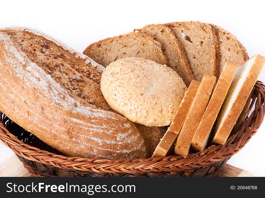 Various bakery products in a basket over white