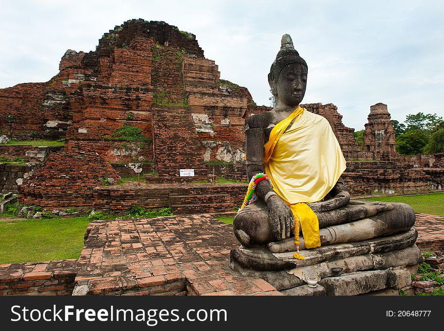 A buddha statue and ruins of a beautiful ancient wat in Ayutthaya, Thailand. A buddha statue and ruins of a beautiful ancient wat in Ayutthaya, Thailand