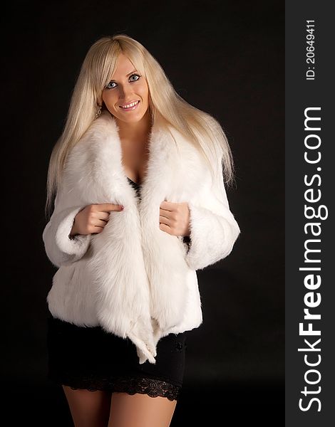 The glamour blonde in a warm white fur coat on a white background. The glamour blonde in a warm white fur coat on a white background