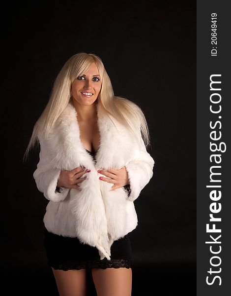 The glamour blonde in a warm white fur coat on a white background. The glamour blonde in a warm white fur coat on a white background