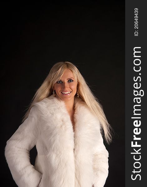 The glamour blonde in a warm white fur coat on a white background. The glamour blonde in a warm white fur coat on a white background