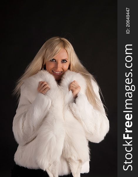 The glamour blonde in a warm white fur coat on a white background. The glamour blonde in a warm white fur coat on a white background