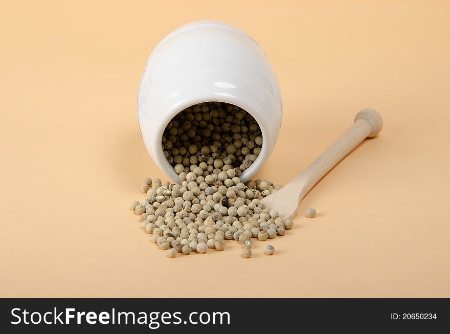 Seeds of white pepper on beige background
