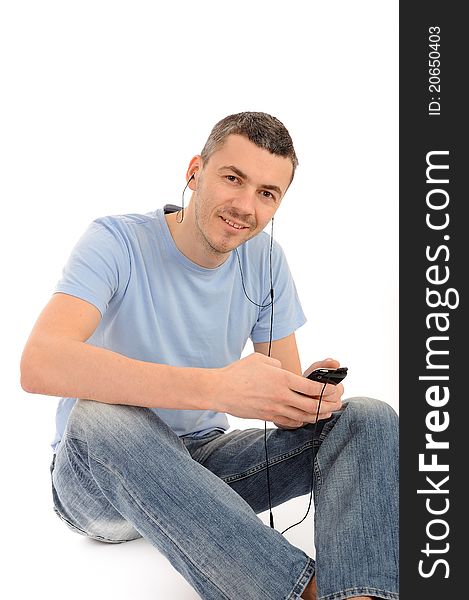 Casual young man with cell phone and headphones. isolated