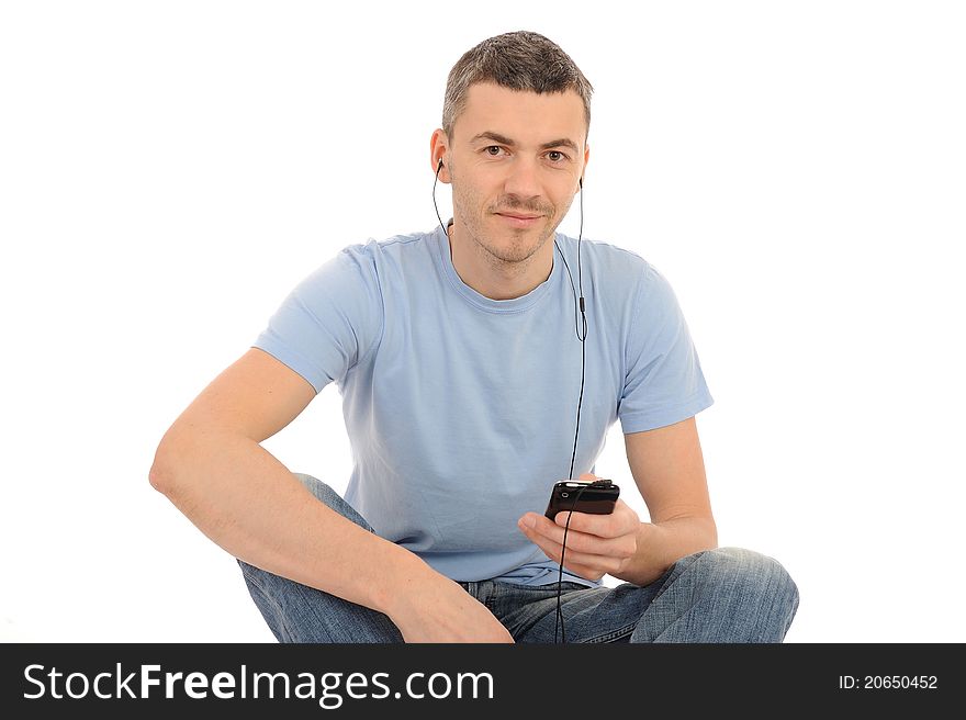 Casual young man with cell phone and headphones. isolated