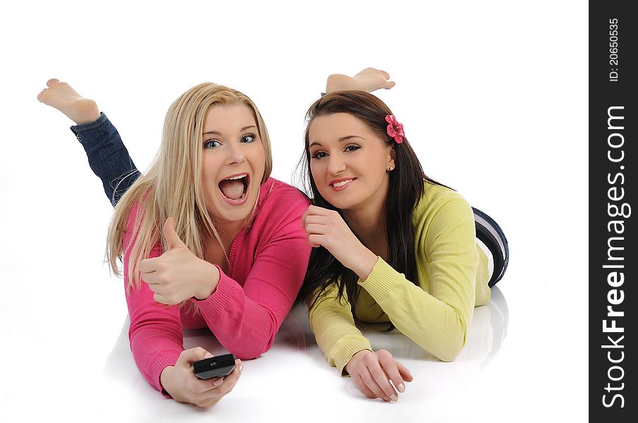 Two young pretty women friends watching television and switching channels on remote control. Two young pretty women friends watching television and switching channels on remote control