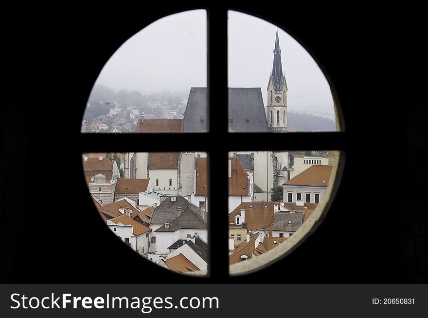 Looking through a round window out on a historic city in Cesky Krumlov, Europe. Looking through a round window out on a historic city in Cesky Krumlov, Europe.