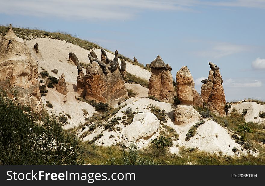Strange sandstone formation of a crown and chimneys. Landscape, copy space crop are, blue cloudy skies,rugged terrian with bushes and greenery. Strange sandstone formation of a crown and chimneys. Landscape, copy space crop are, blue cloudy skies,rugged terrian with bushes and greenery.