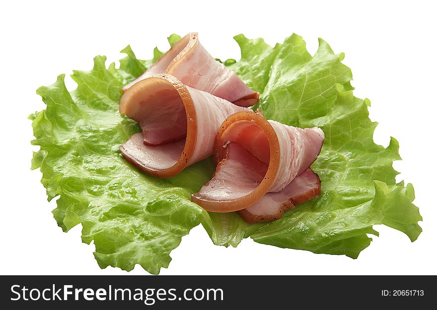 Some pieces of bacon on the green lettuce