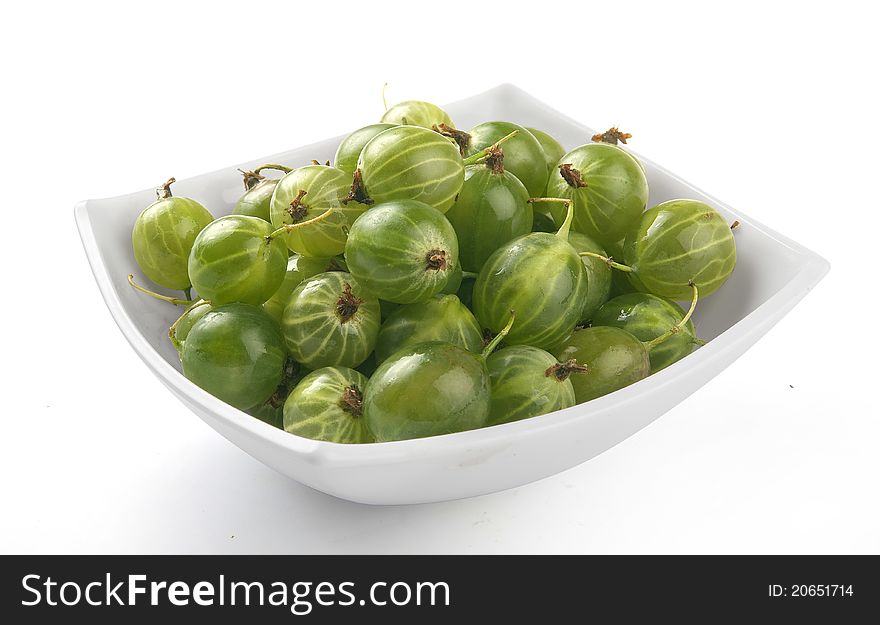 Handful of green gooseberries in the white plate