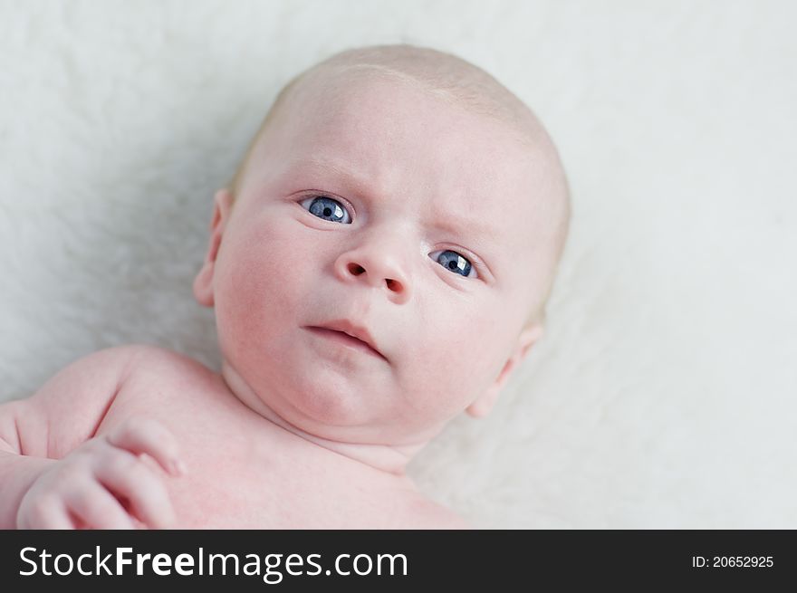 Newborn boy with blue eyes closeup