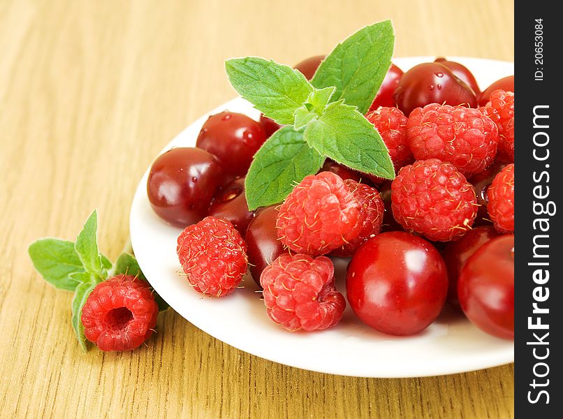 Plate with cherries and raspberries. Plate with cherries and raspberries