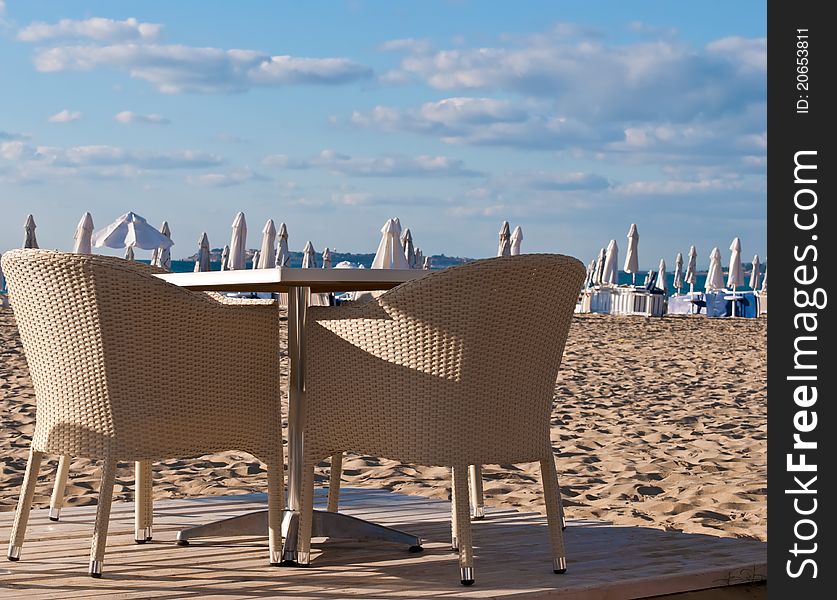 View of the beach with street cafe , table, chair , loungers and umbrellas. View of the beach with street cafe , table, chair , loungers and umbrellas.