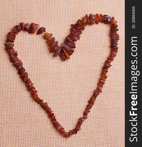 Corals with shape of heart on the straw background.