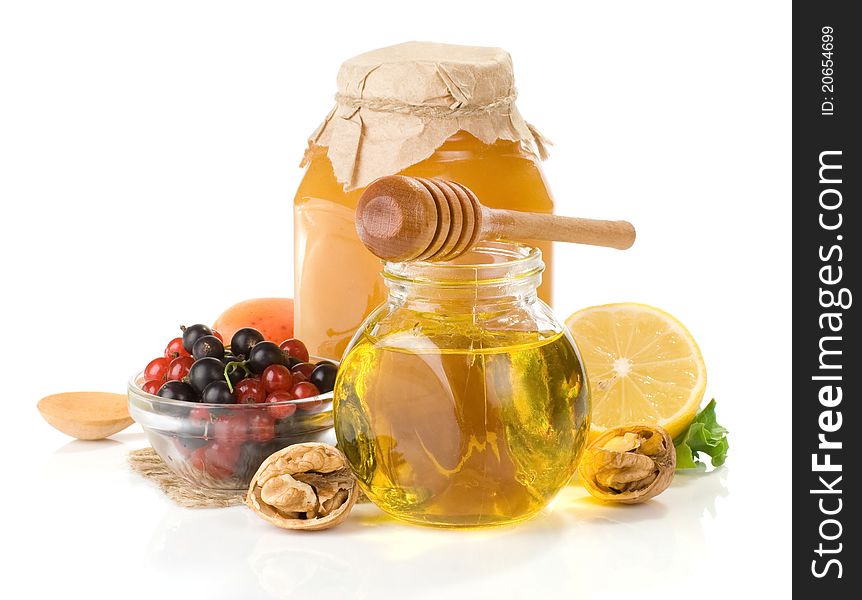 Glass jar full of honey, lemon and berry isolated on white background