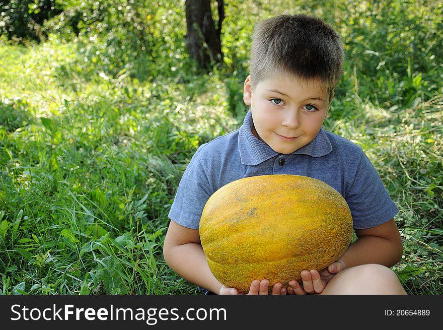 A boy with a large melon in his hands