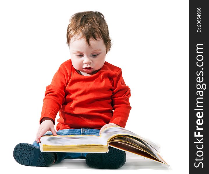 Little boy reads the book interestedly on a white background