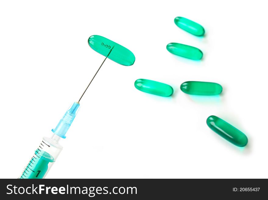 Syringe with needle and blue pills on white background. Syringe with needle and blue pills on white background.