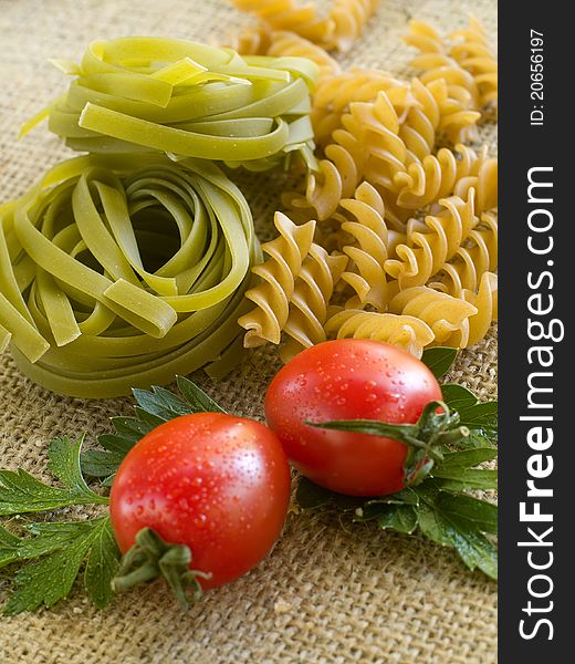 Pasta ingredients; fresh tagliatelli and fusilli, tomato, parsley Selective focus